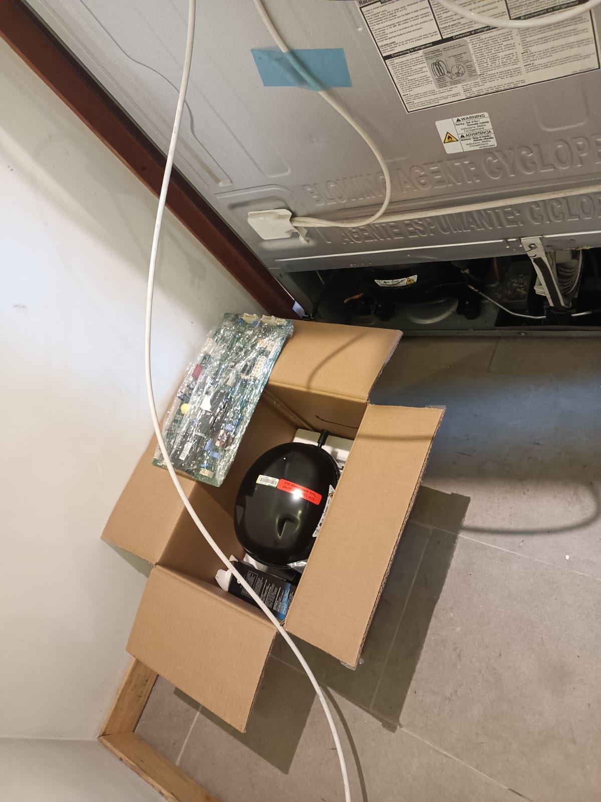 Técnico realizando cambio de compresor de nevera